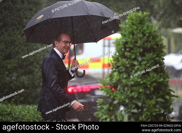 25 July 2023, Bavaria, Bayreuth: Alexander Dobrindt, chairman of the CSU in the Bundestag, arrives in the rain for the opening of the Richard Wagner Festival...