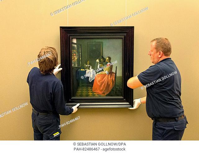 Art handlers straighten the painting during the hanging of Jan Vermeer's painting 'The Girl with the Wine Glass' in the Herzog Anton Ulrich Museum in...