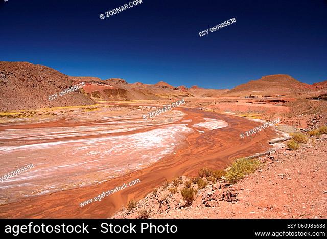 Riverbed of a red river flowing through wide valley in northern Argentina