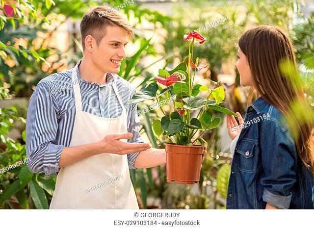 Male florist helping young female choosing the right flower