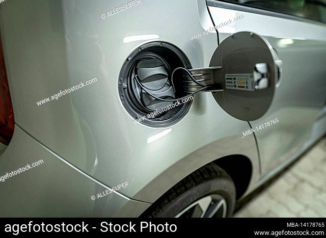 Open fuel cap of a electric car which is ready to get recharged with green power eco electricity