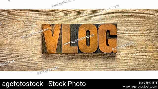 vlog (video blog) word in vintage letterpress wood type against wooden plank, social media, web television and internet communication concept