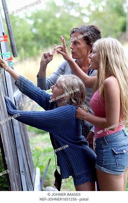 Mother with daughters playing darts