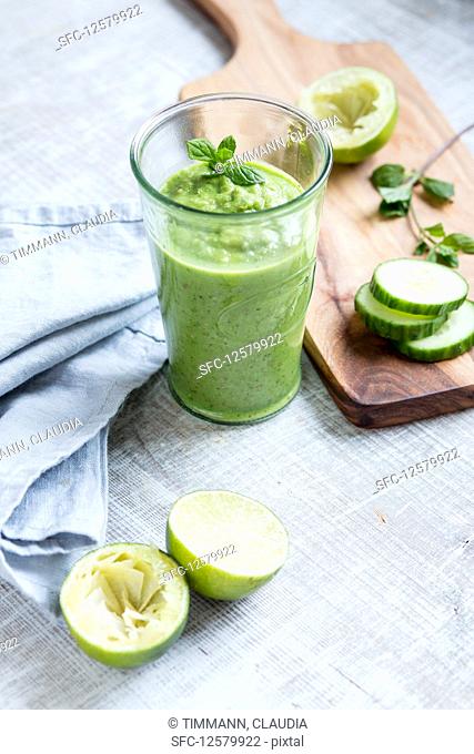 A green smoothie with cucumber and limes