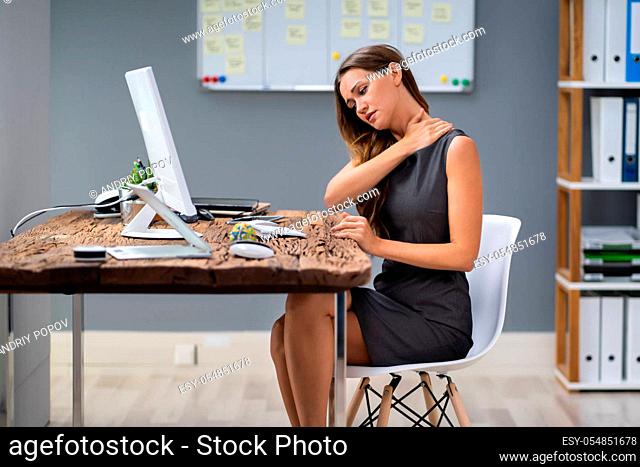 Young Businesswoman Suffering From Neck Pain At Office