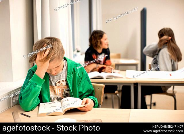 Boy reading in classroom