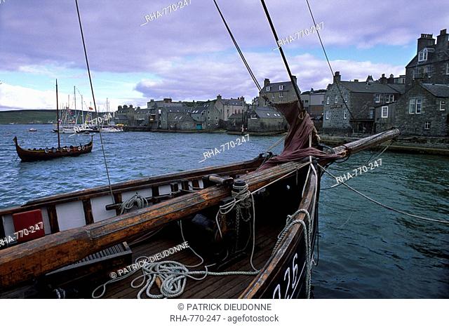 Lerwick seafront, with wharves and slipways, and stone warehouses lodberries, from a zulu replica, with Viking ship replica on left, Shetland Islands, Scotland