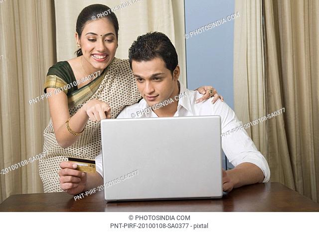 Couple doing home shopping on a laptop