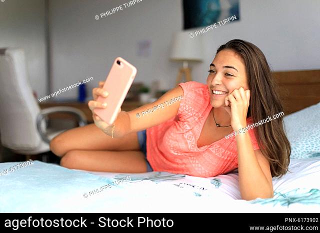 Young teenager at home with a smartphone. Selfie