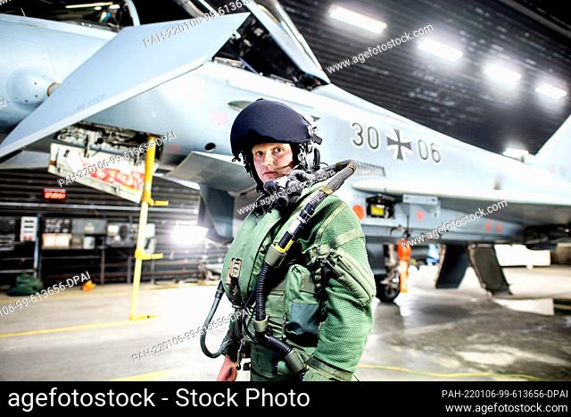 06 January 2022, Lower Saxony, Wittmund: Major Hannes stands in front of a Luftwaffe Eurofighter Typhoon fighter aircraft in a hangar at Wittmundhafen Air Base
