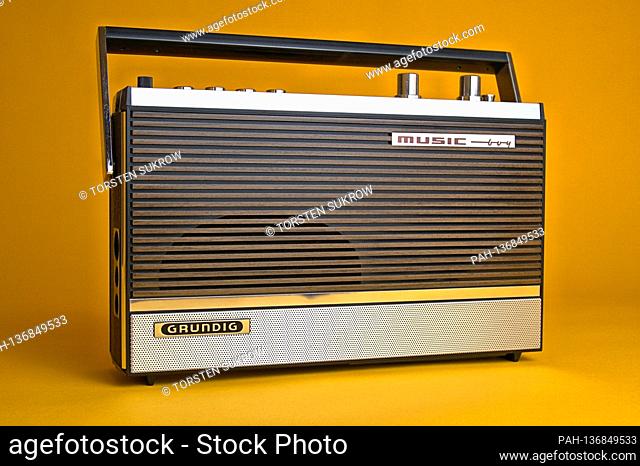 An old portable radio made by Grundig, type Music-Boy 209, which was built and sold from 1969 to 1970. Photo against a vintage 1970s style background
