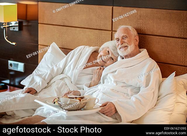 Good time. Senior couple spending weekend in a hotel and looking contented