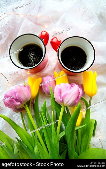 Beautiful morning, two cups of coffee and a bouquet of bright tulips