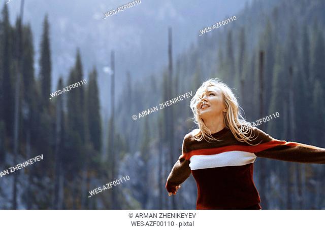 Happy blond woman, arms outstretched