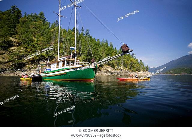 Kayakers launch from 'Misty Isles', a 43 ft gaff rigged Schooner, in Desolation Sound Canada.Vancouver Island, British Columbia, Canada