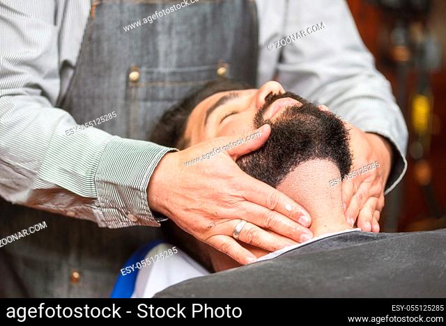 Hair stylist applying after shaving lotion at barber shop