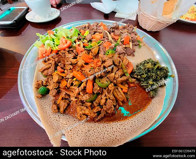 Ethiopian food injera bread with steak meat and tomatoes