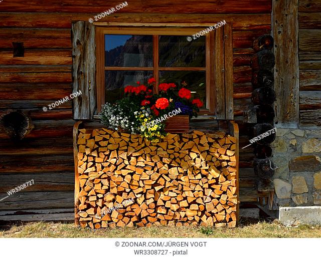 Blumenfenster; Blumenschmuck; Holzstapel; Almhuette; Dolomiten; Dolomite alps; Suedtirol; South Tyrol; Italy; Floral decoration; flower window; firewood pile;...