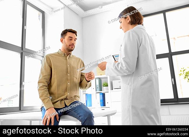 doctor giving prescription to patient at hospital