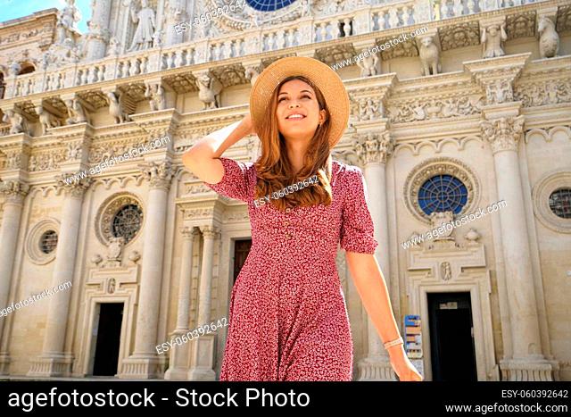 Holidays in Italy. Beautiful smiling woman in long dress and hat visiting the baroque city of Lecce, Salento, Italy