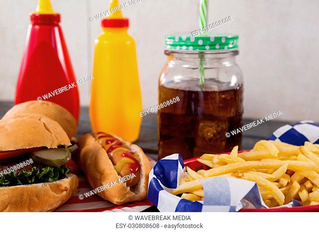 Close-up of snacks and cold drink on wooden table