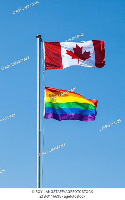 Gay Pride flag flying under the Maple Leaf during Pride Week in Vancouver, British Columbia