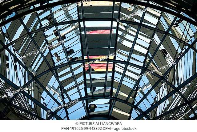 25 October 2019, Berlin: Visitors and the German flag are reflected in the Reichstag dome during the 122nd session of the German Bundestag
