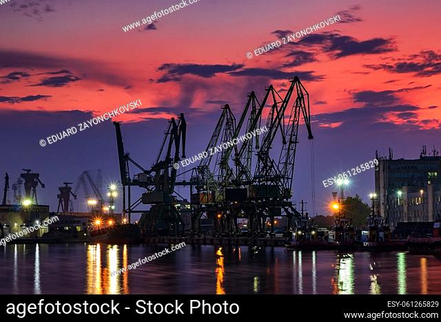 the silhouette of port cranes, at stunning twilight