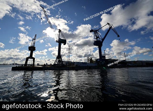 PRODUCTION - 19 October 2022, Mecklenburg-Western Pomerania, Warnemünde: Cranes stand at the flooded dry dock of the naval arsenal, formerly MV Werften