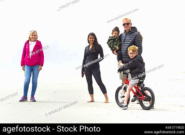 Family on the beach, in fog, near Tofino, British Columbia, Canada