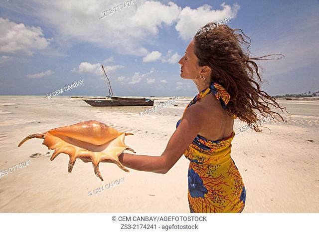 Woman holding a sea shell, Jambiani, Zanzibar Island, Tanzania, Indian Ocean, East Africa
