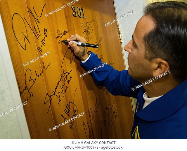 Expedition 31 Flight Engineer Joe Acaba performs the tradition of signing one of the doors at the Cosmonaut Hotel on May 15, 2012 in Baikonur, Kazakhstan