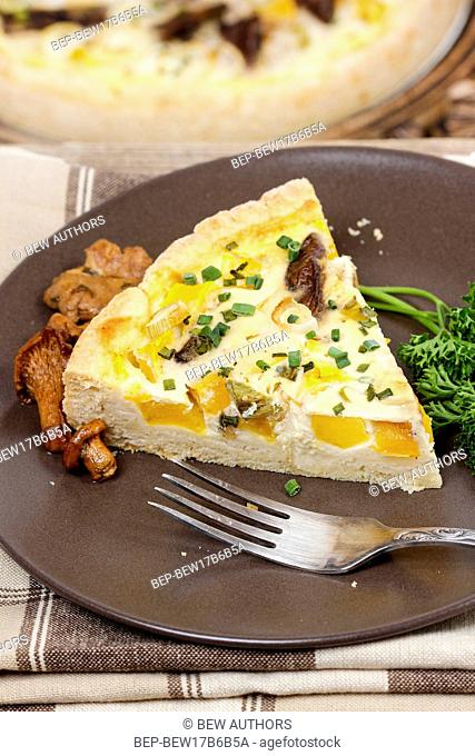 Piece of quiche lorraine on brown plate. Autumn setting