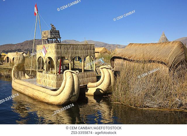 Tourist at the top of a Totora reed boat at the Uros Islands, Lake Titicaca, Puno Province, Peru, South America