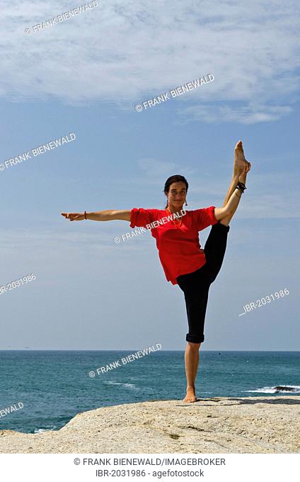 Woman in a yoga position, Anjaneyasana, by the sea in Kanyakumari, Tamil Nadu, India, Asia