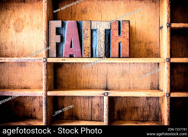 The word FAITH written in vintage wooden letterpress type in a wooden type drawer