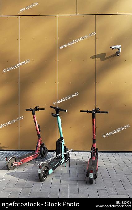 Three e-scooters correctly parked on the pavement, under a surveillance camera, Düsseldorf, North Rhine-Westphalia, Germany, Europe