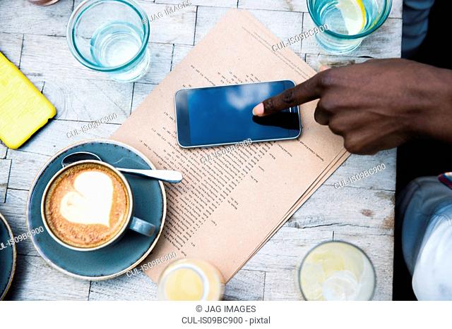 Coffee, mobile phone, menu on wooden table