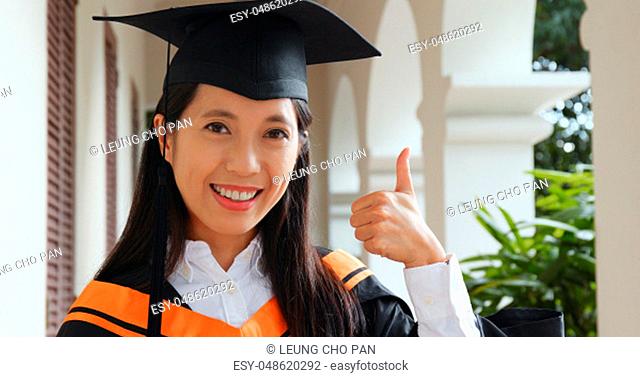 Woman get graduation and show thumb up