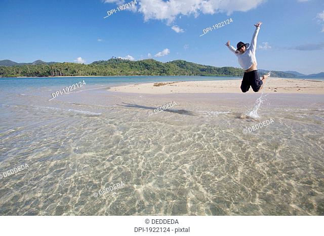man jumping above the tropical water, bacuit archipelago, palawan, philippines