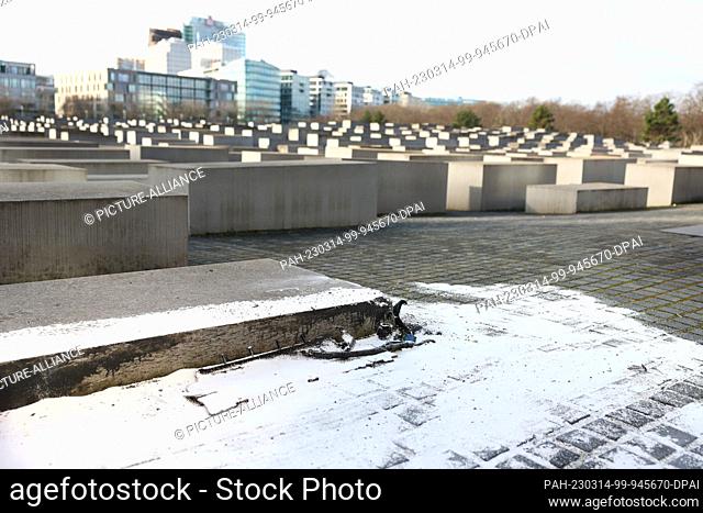 14 March 2023, Berlin: Debris from the car that crashed into a low stele of the Holocaust Memorial on Tuesday night lies at the scene of the accident