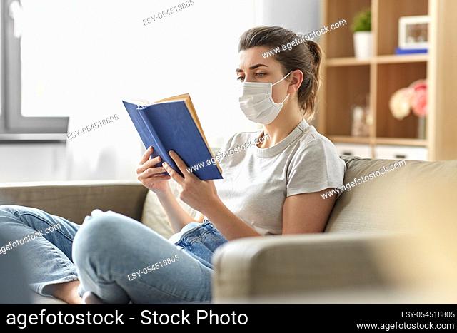 sick woman in medical mask reading book at home