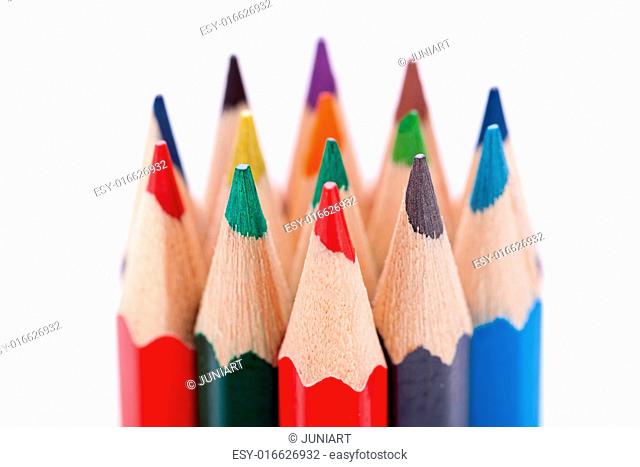 Bunch of sharpened wooden colourful pencil crayons in the colours of the spectrum or rainbow on a white background symbolising art and creativity
