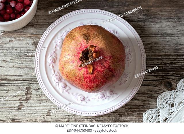 Fresh pomegranate on a vintage plate, top view
