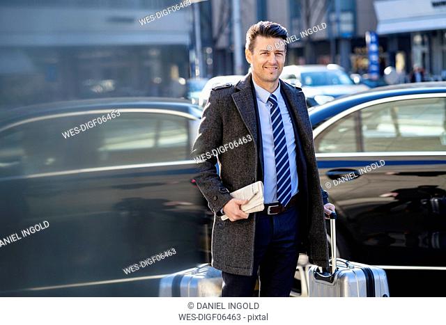 Businessman with suitcase at the street in the city