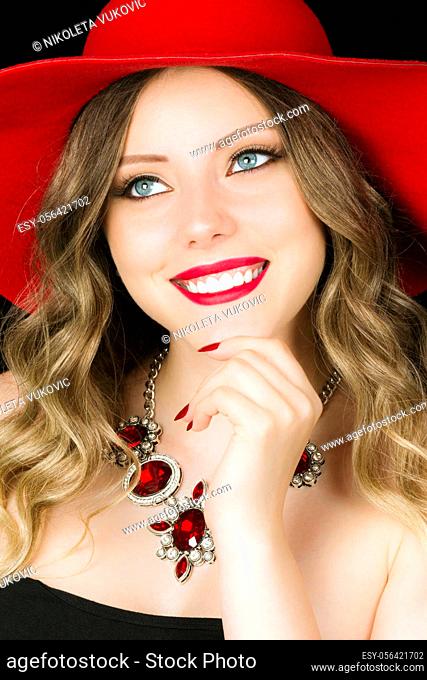 Glamorous beauty portrait of smiling beautiful blond hair woman with red hat and necklace