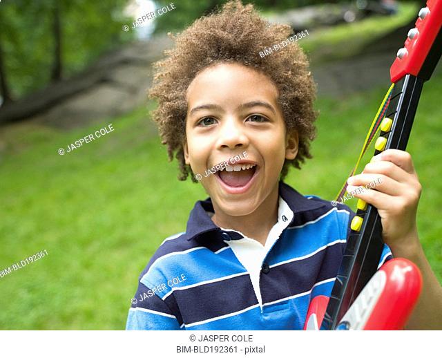 Mixed race boy with plastic guitar