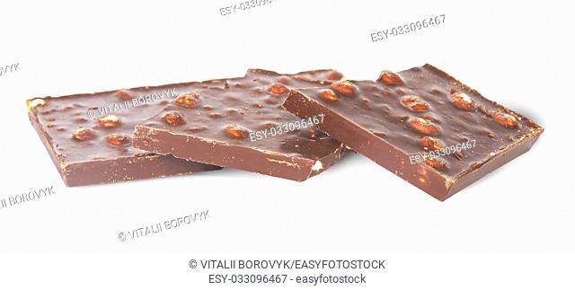 Several pieces of dark chocolate with hazelnuts isolated on white background