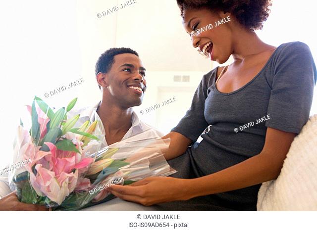 Young man giving woman bouquet