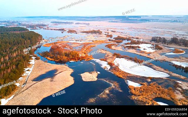 Spring melting river flood aerial panorama. Overflow water at springtime. Rural sunrise landscape. Meadows covered by water